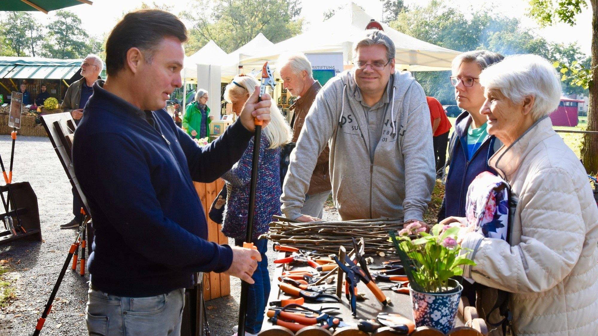 Ein Mann zeigt Festbesuchern Werkzeuge