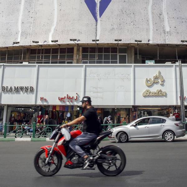 A man rides his motorcycle past an anti-Israel billboard with the chequerred keffiye covering the Star of David, entitled "Operation Al-Aqsa Flood," in solidarity with the Palestinians in Tehran's central Vali-Asr square on October 8, 2023. The Israeli-Palestinian conflict's bloodiest escalation in decades saw Hamas carry out a massive rocket barrage and ground, air and sea operation on October 7 that Israel's army said had killed more than 200 Israelis and wounded 1,000, while soldiers and civilians were taken hostage. (Photo by AFP)