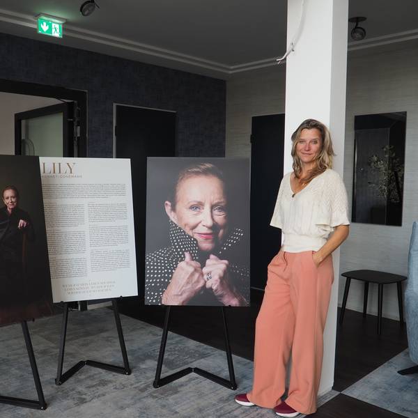 Eine Frau steht neben Plakaten.