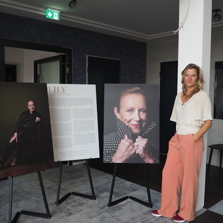 Eine Frau steht neben Plakaten.
