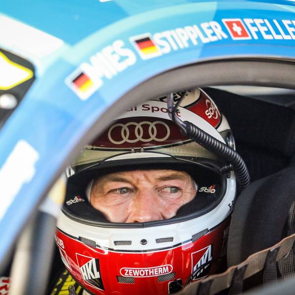 Rennfahrer Frank Stippler sitzt, mit geöffnetem Visier, in seinem Rennwagen.