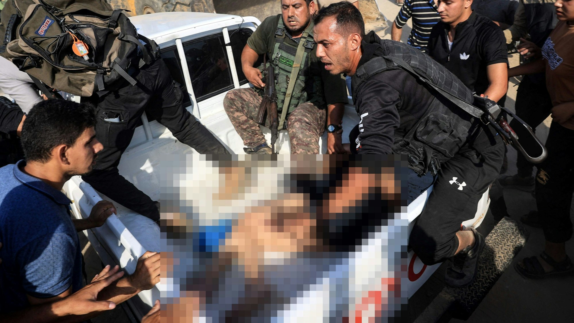 Militante Palästinenser umringen am 7. Oktober im Gazastreifen einen Pick-up, auf dem ein Entführungsopfer liegt.