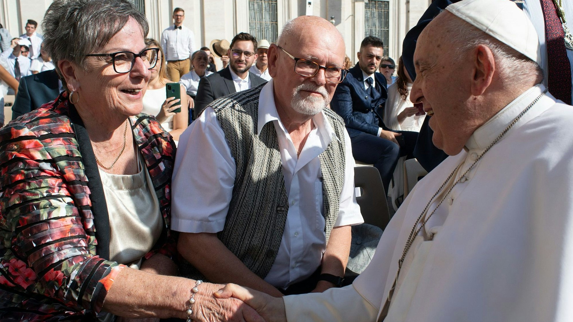 Papst Franziskus schüttelt Gisela Schwarzbach die Hand, ihr Ehemann Eberhard steht daneben.