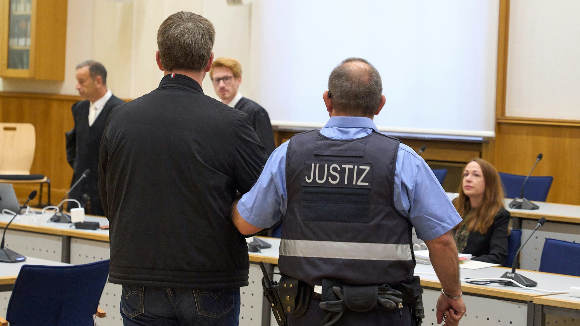 Koblenz: Der Angeklagte (vorne links) wird in den Gerichtssaal des Oberlandesgerichts zur Verkündung des Urteils geführt.