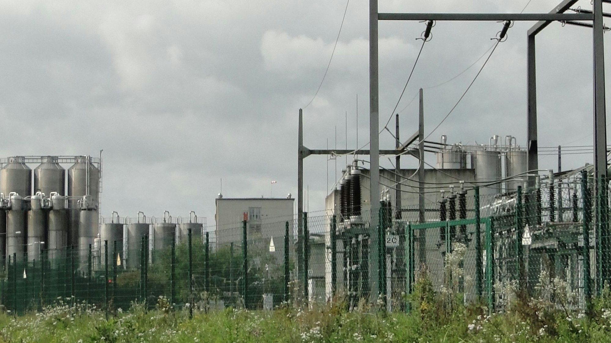 Ein Umspannwerk ist vor einem Chemie-Unternehmen zu sehen.