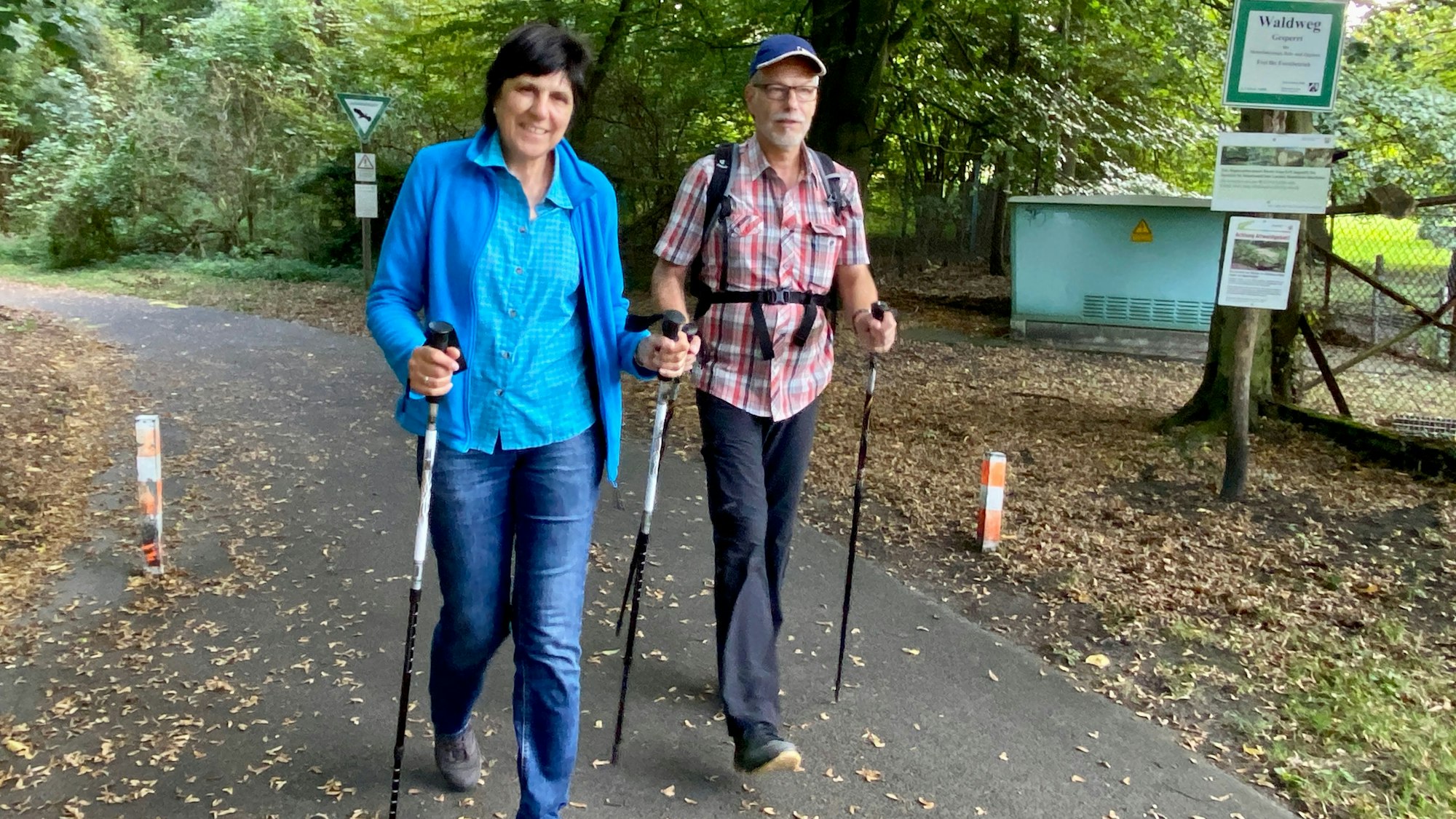 Das Foto zeigt die beiden Wanderer Ute und Michael Pliester, im Hintergrund ist der herbstliche Wald zu sehen.