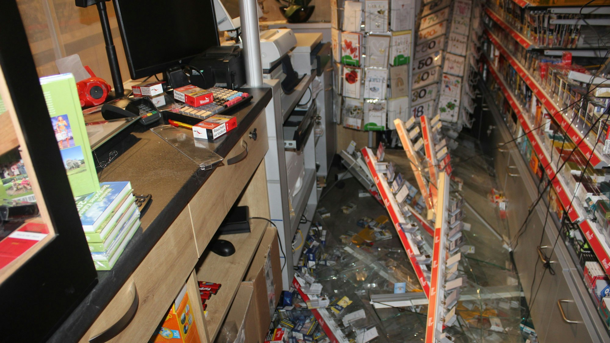 Herausgerissene Regale liegen zerstört in einem Gang des Lottogeschäfts.