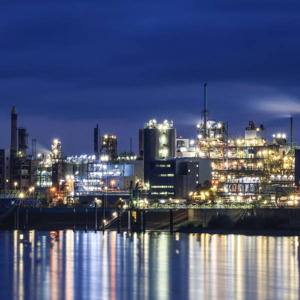 Lichter von Werksanlagen auf dem Chempark in Leverkusen spiegeln sich im Rhein.