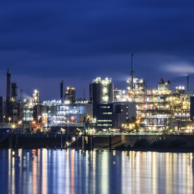 Lichter von Werksanlagen auf dem Chempark in Leverkusen spiegeln sich im Rhein.
