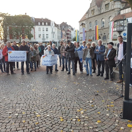 Auf dem Konrad-Adenauer-Platz demonstrieren Menschen mit Plakaten und Israel-Fahnen.