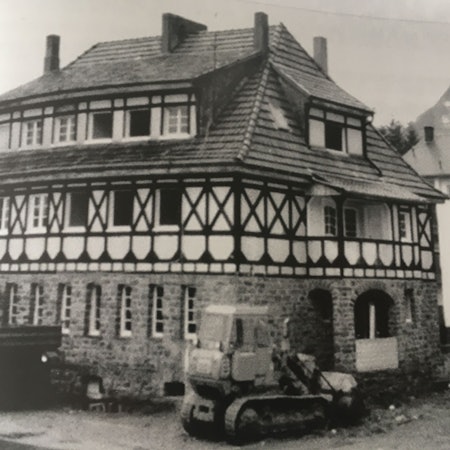 Baufahrzeuge stehen vor einem alten Gebäude.