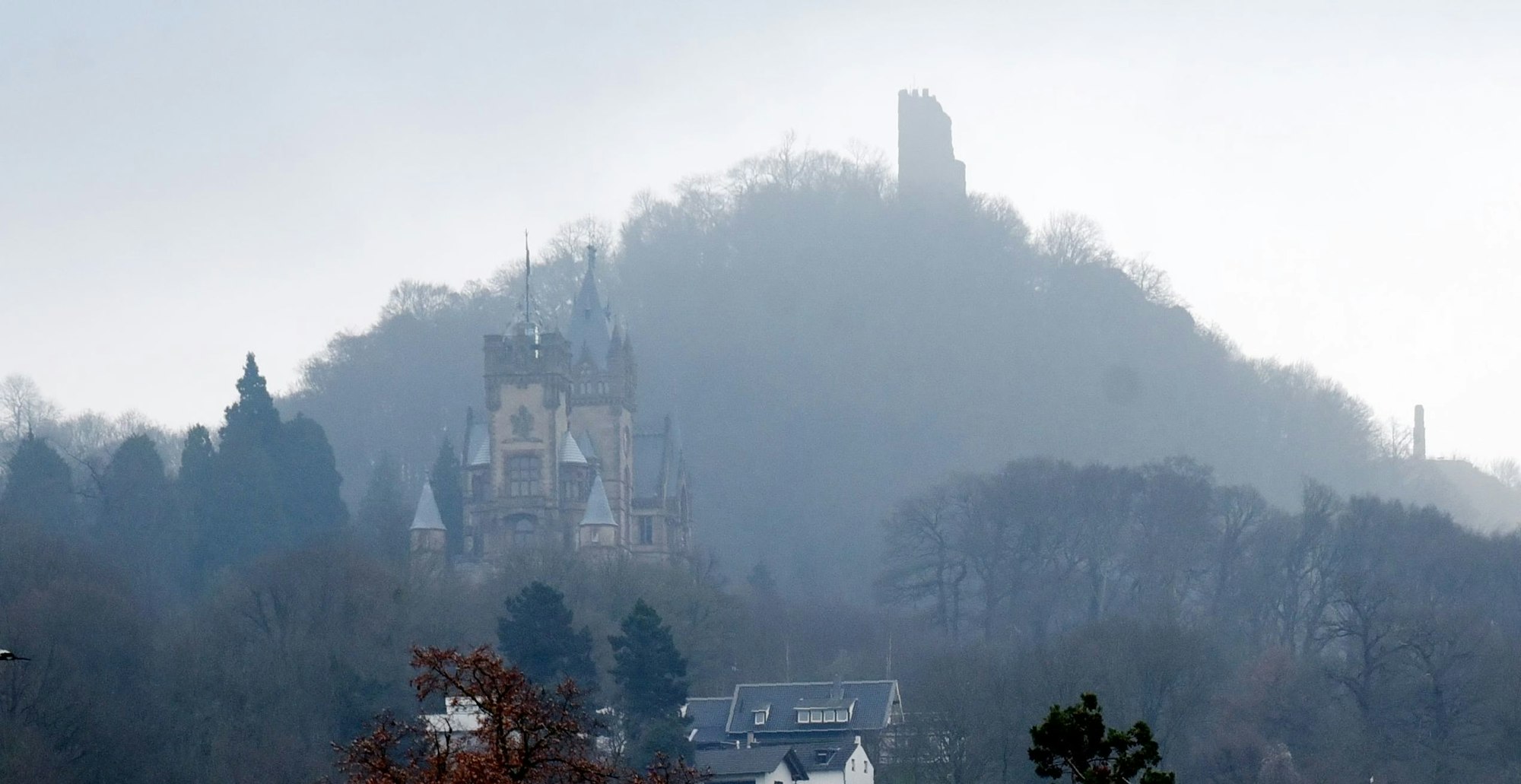 Drachenburg und Drachenfels im Nebel.