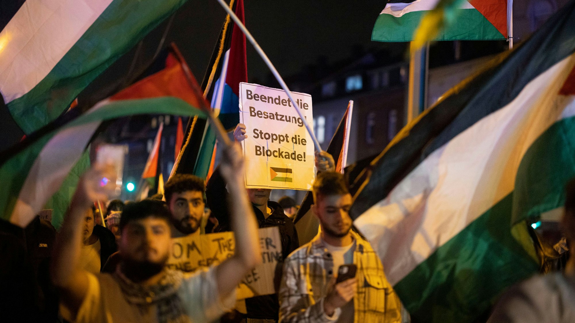 09.10.2023, Nordrhein-Westfalen, Duisburg: «Beendet die Besatzung - Stoppt die Blockade», heißt es auf einem Banner eines Demonstranten nach einer pro-palästinensischen Kundgebung. Nach der Kundgebung zogen Teilnehmer etwa einen Kilometer durch den Stadtteil Hochfeld und schwenkten palästinensische Flaggen. Foto: Christoph Reichwein/dpa +++ dpa-Bildfunk +++