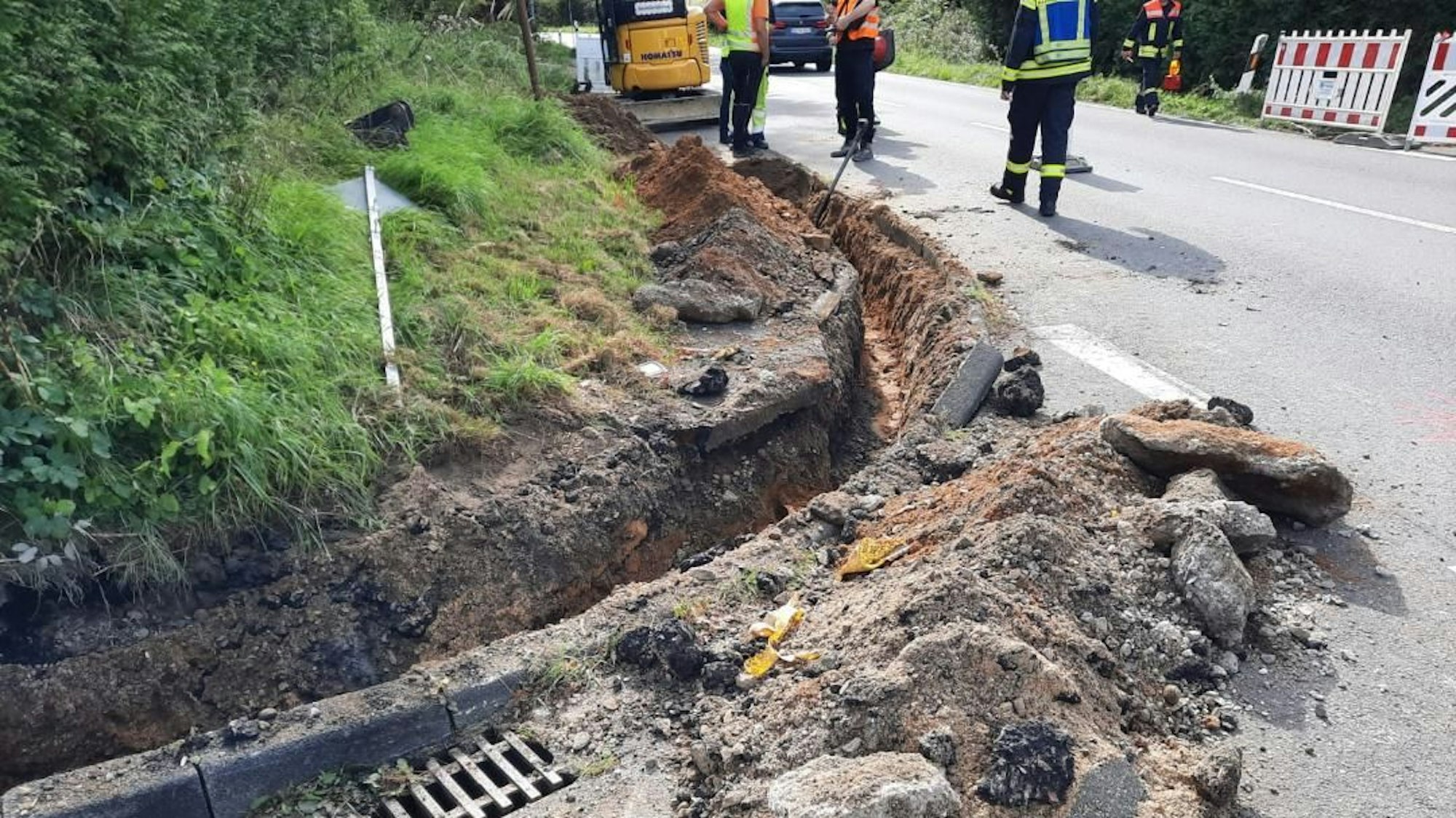 Ein ausgebaggerter Graben am einer Straßenkreuzung.