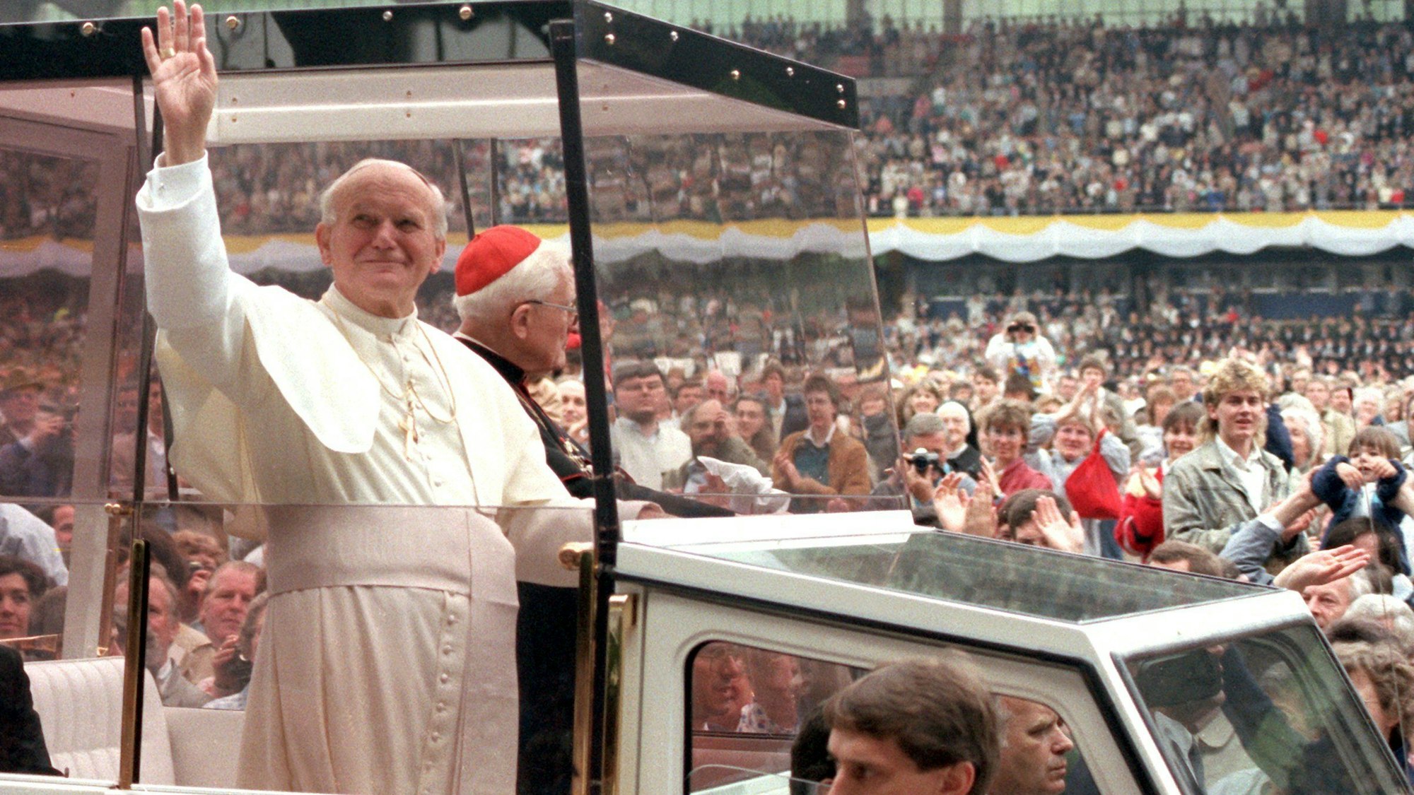 Papst Johannes Paul II. fährt mit einem kleinen Wagen durch das Müngersdorfer Stadion in Köln.