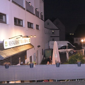 Viele Menschen stehen vor einem Gebäude.