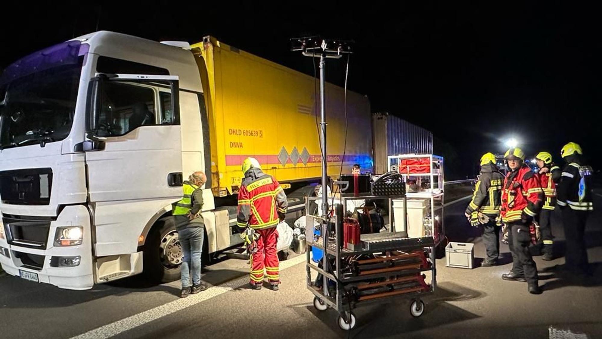 Feuerwehrleute stehen vor einem LKW.