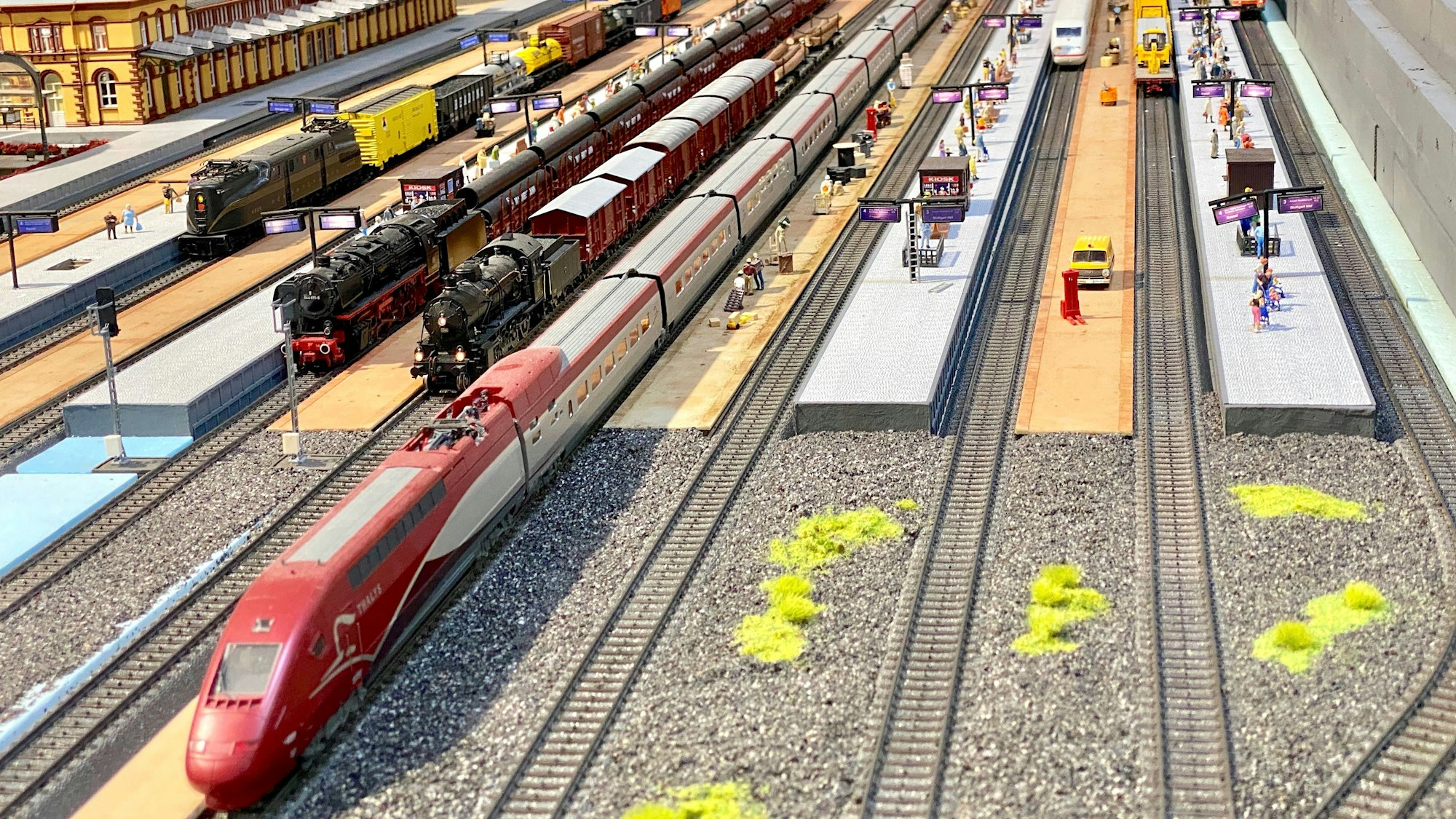 Die Modelleisenbahn-Landschaft steht in einer Halle voller Regale und Modellen.