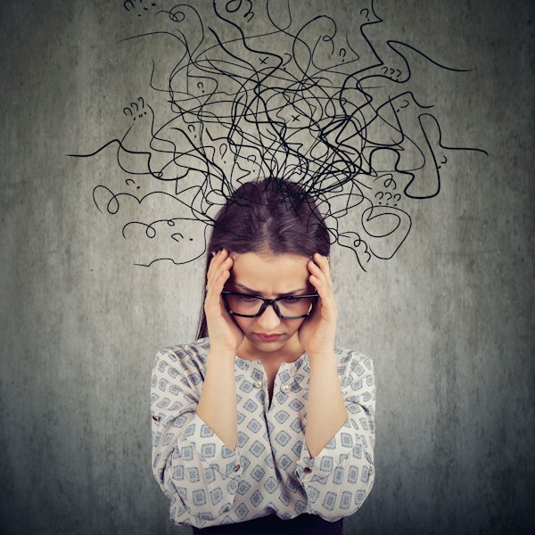 Eine Frau schaut zu Boden, aus ihrem Kopf kommen symbolisch zahlreiche Linien und Fragezeichen.