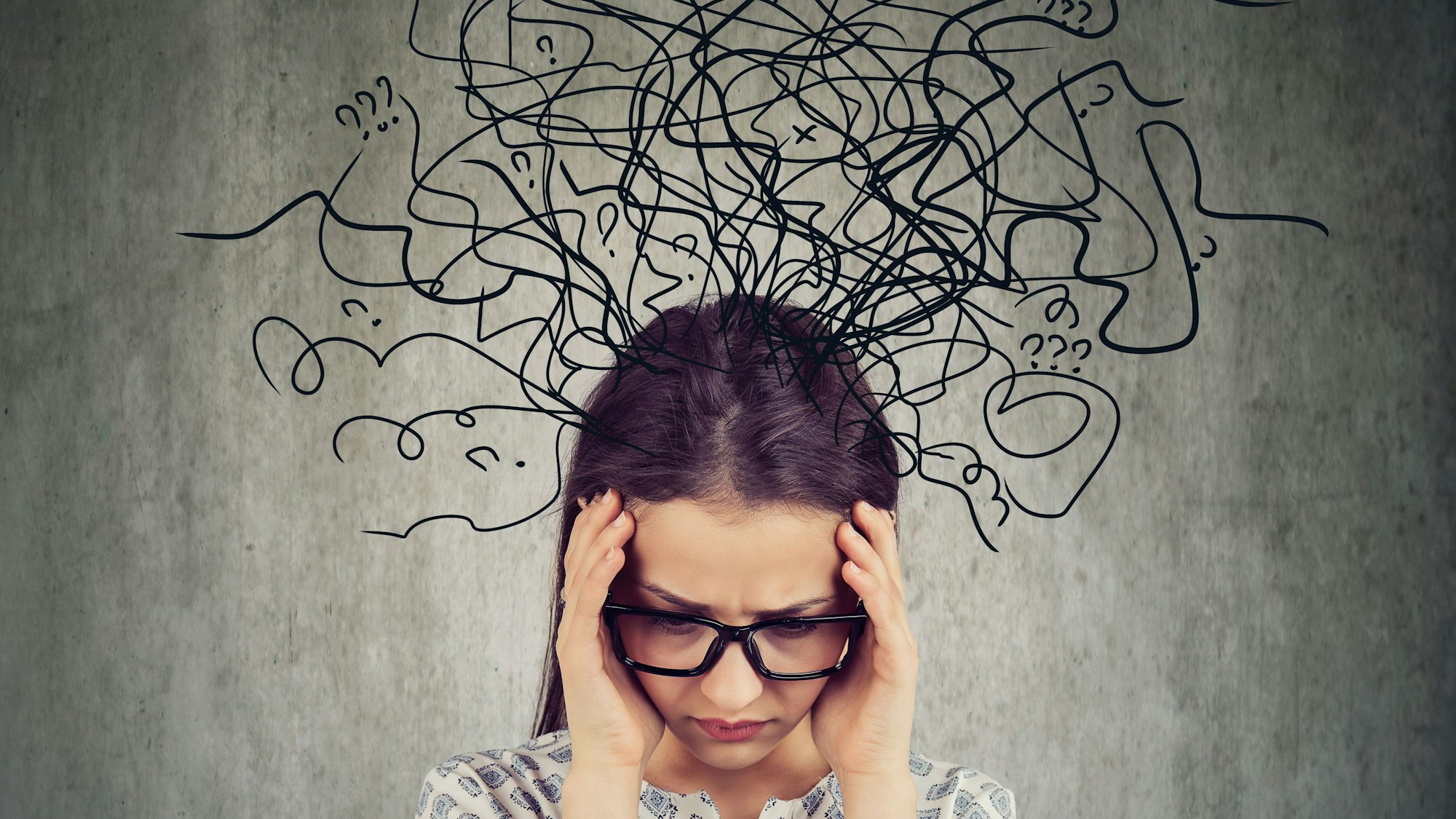 Eine Frau schaut zu Boden, aus ihrem Kopf kommen symbolisch zahlreiche Linien und Fragezeichen.