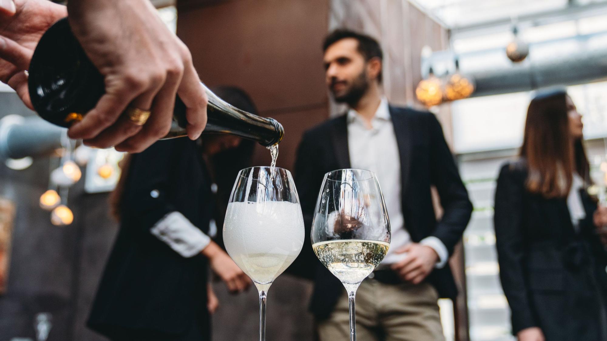 Kellner gießt in einem Restaurant Sekt in ein Glas