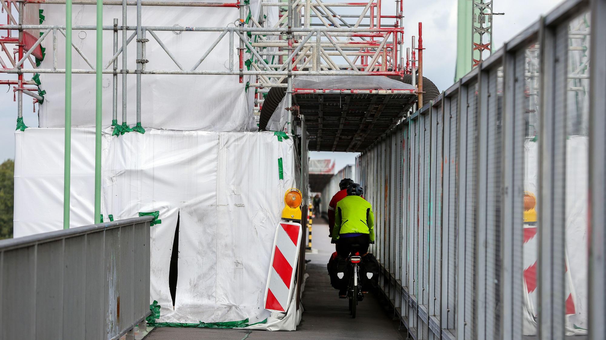 Radfahrer passieren eine Engstelle im Baustellenbereich auf der Rodenkirchener Brücke.