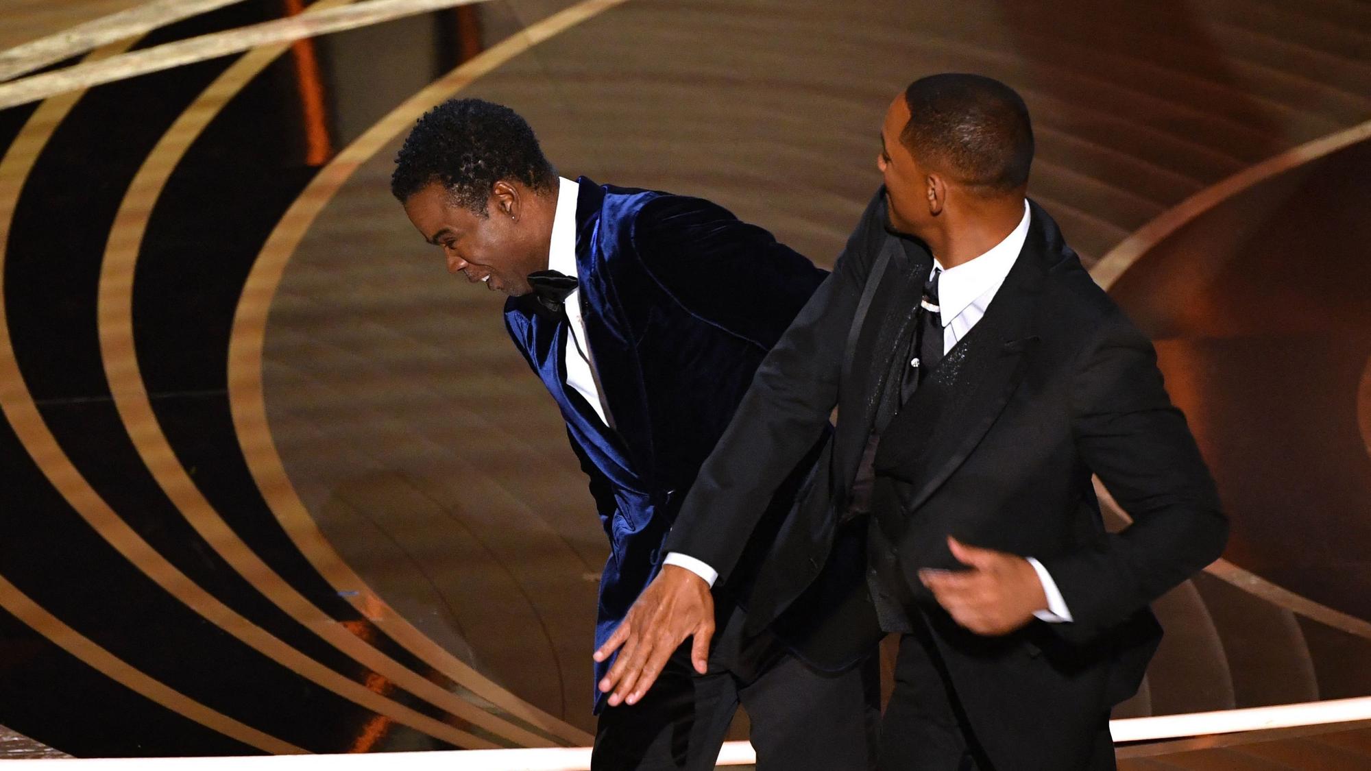 Moderator Chris Rock (l) reagiert, nachdem er auf der Bühne von Will Smith eine Ohrfeige versetzt bekam, bei der 94. Verleihung der Academy Awards in Hollywood.
