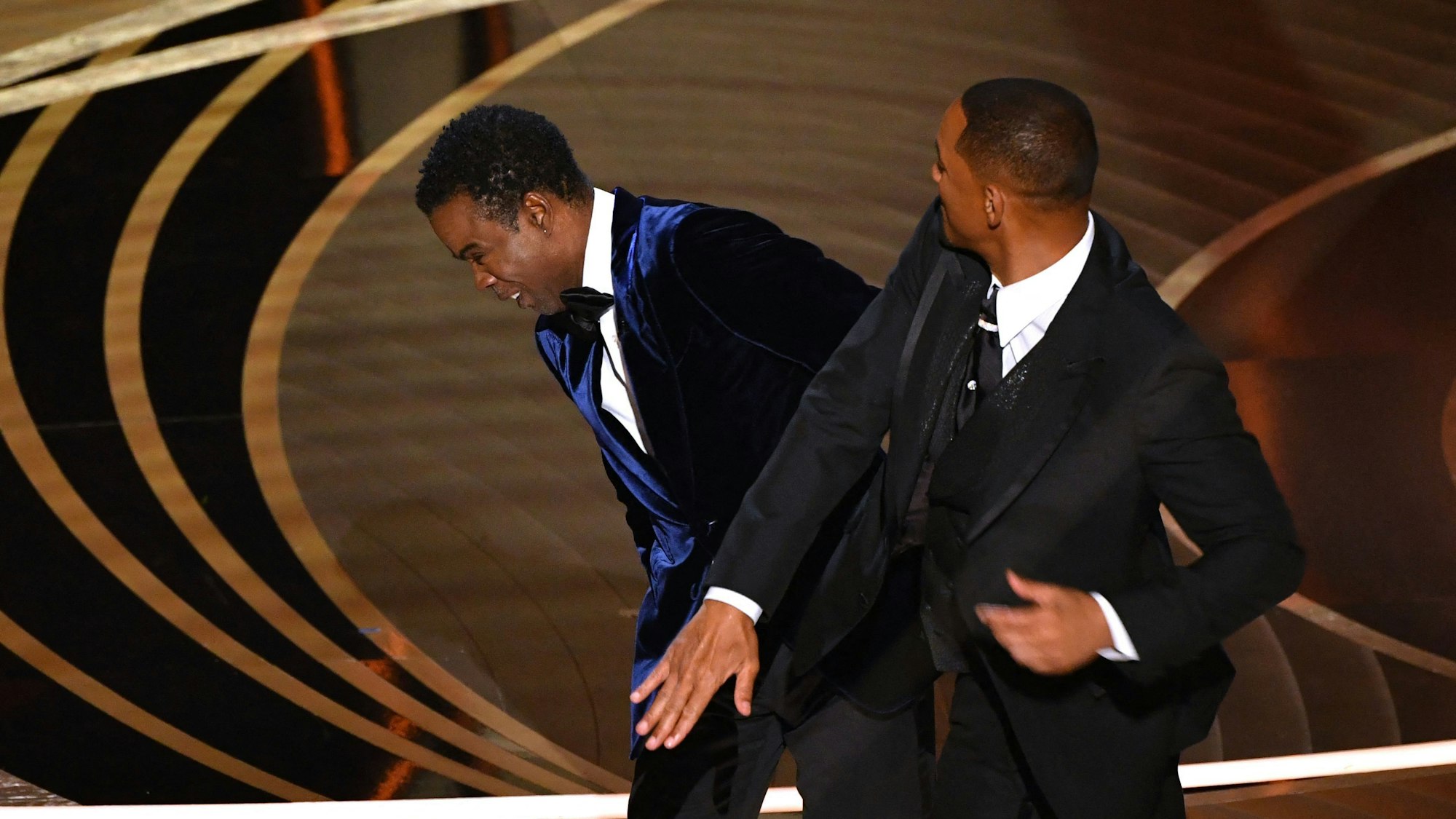 Moderator Chris Rock (l) reagiert, nachdem er auf der Bühne von Will Smith eine Ohrfeige versetzt bekam, bei der 94. Verleihung der Academy Awards in Hollywood.