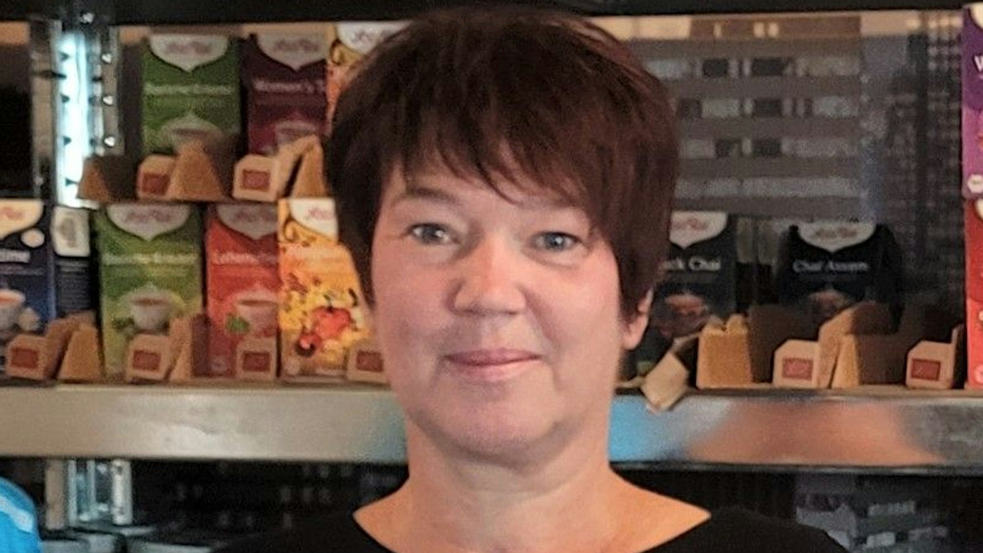 Kirsten Althoff steht vor einem mit Lebensmitteln gefüllten Regal.