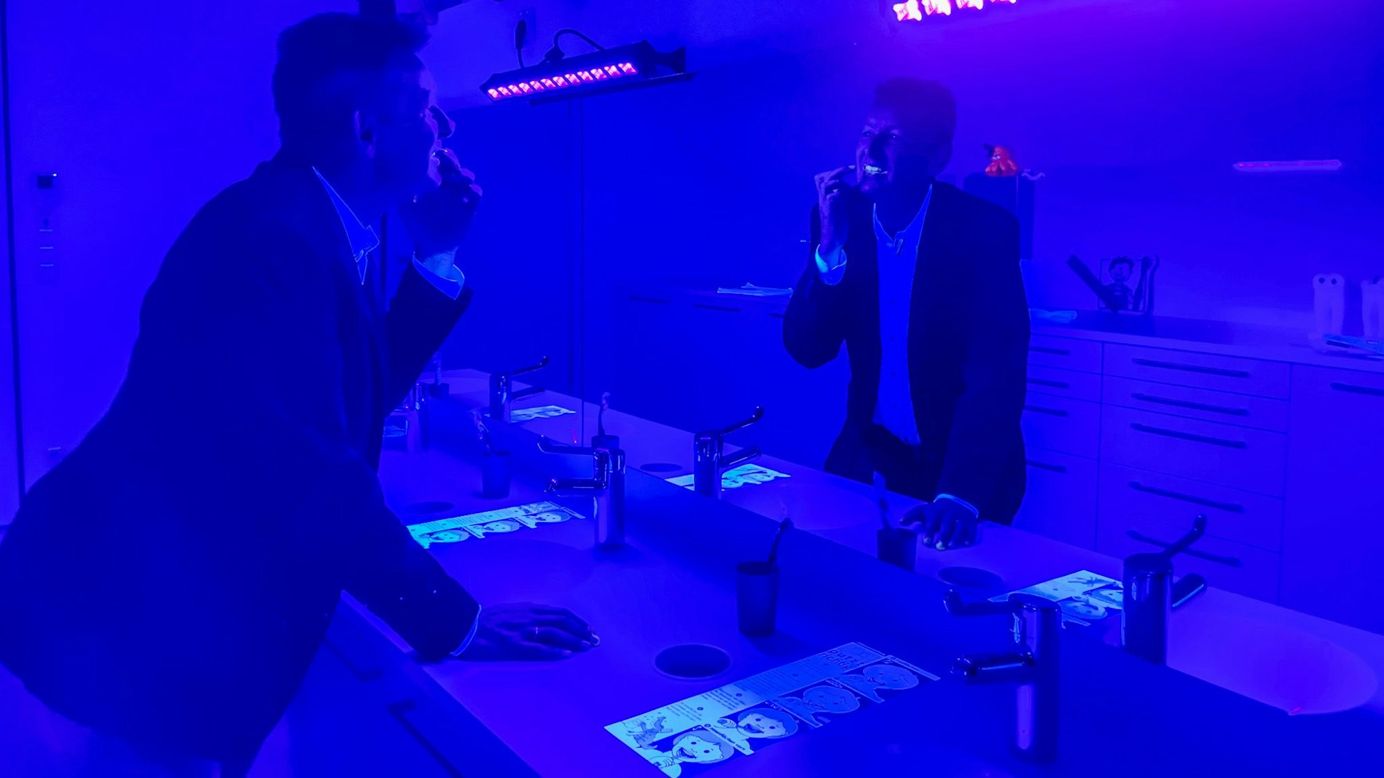 Dr. Tilman Kramer zeigt im Schwarzlicht, wo Zähne noch besser geputzt werden können.