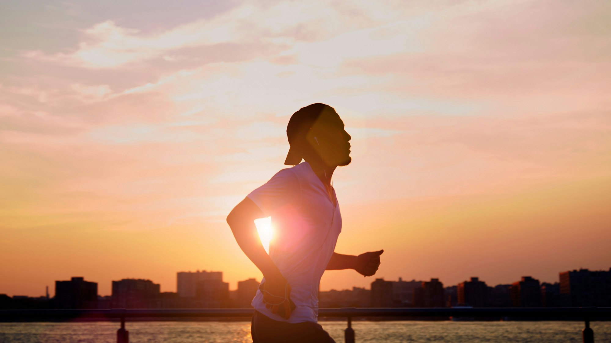 Mann joggt im Sonnenaufgang