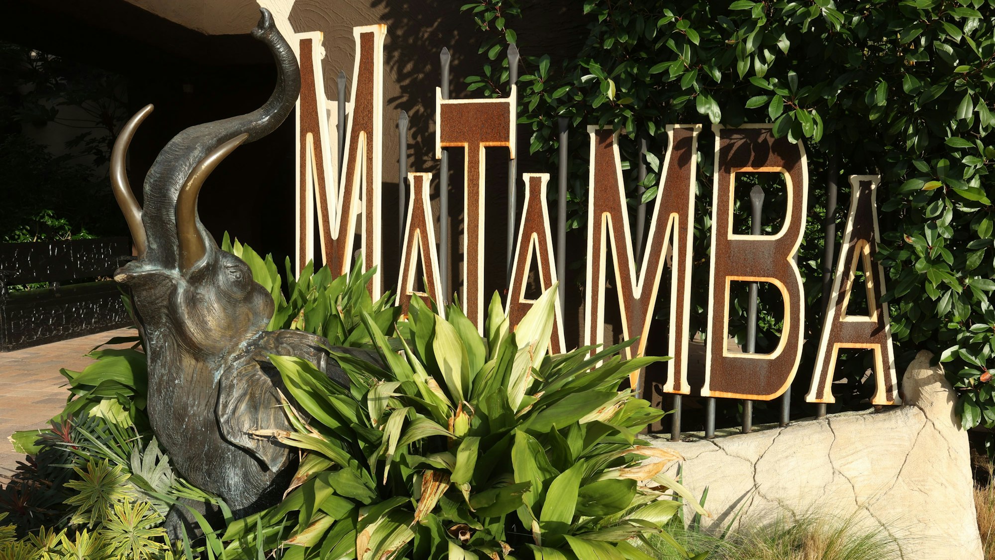 Ein Schild mit dem Namen des Hotels in braunen Buchstaben.