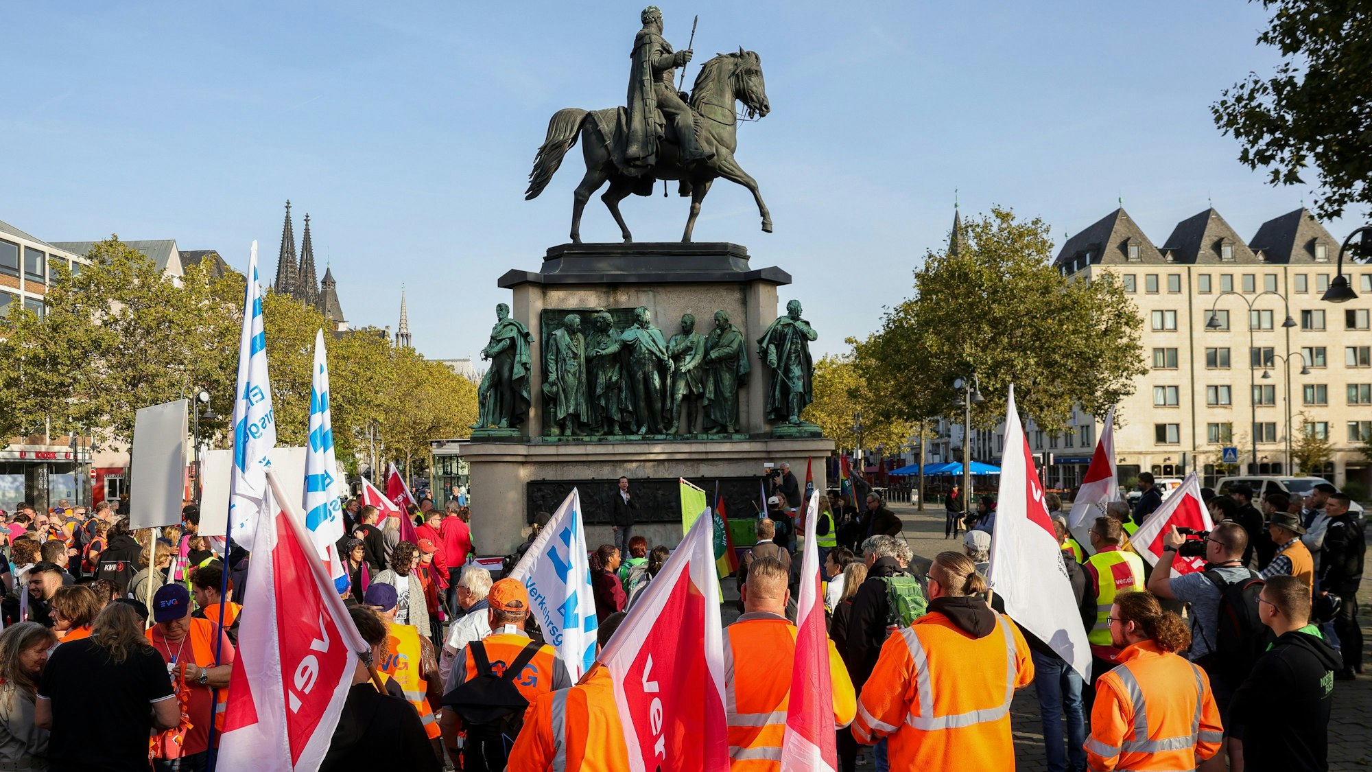 Mehrere Protestierende mit orangefarbenen Warnwesten stehen auf dem Heumarkt.