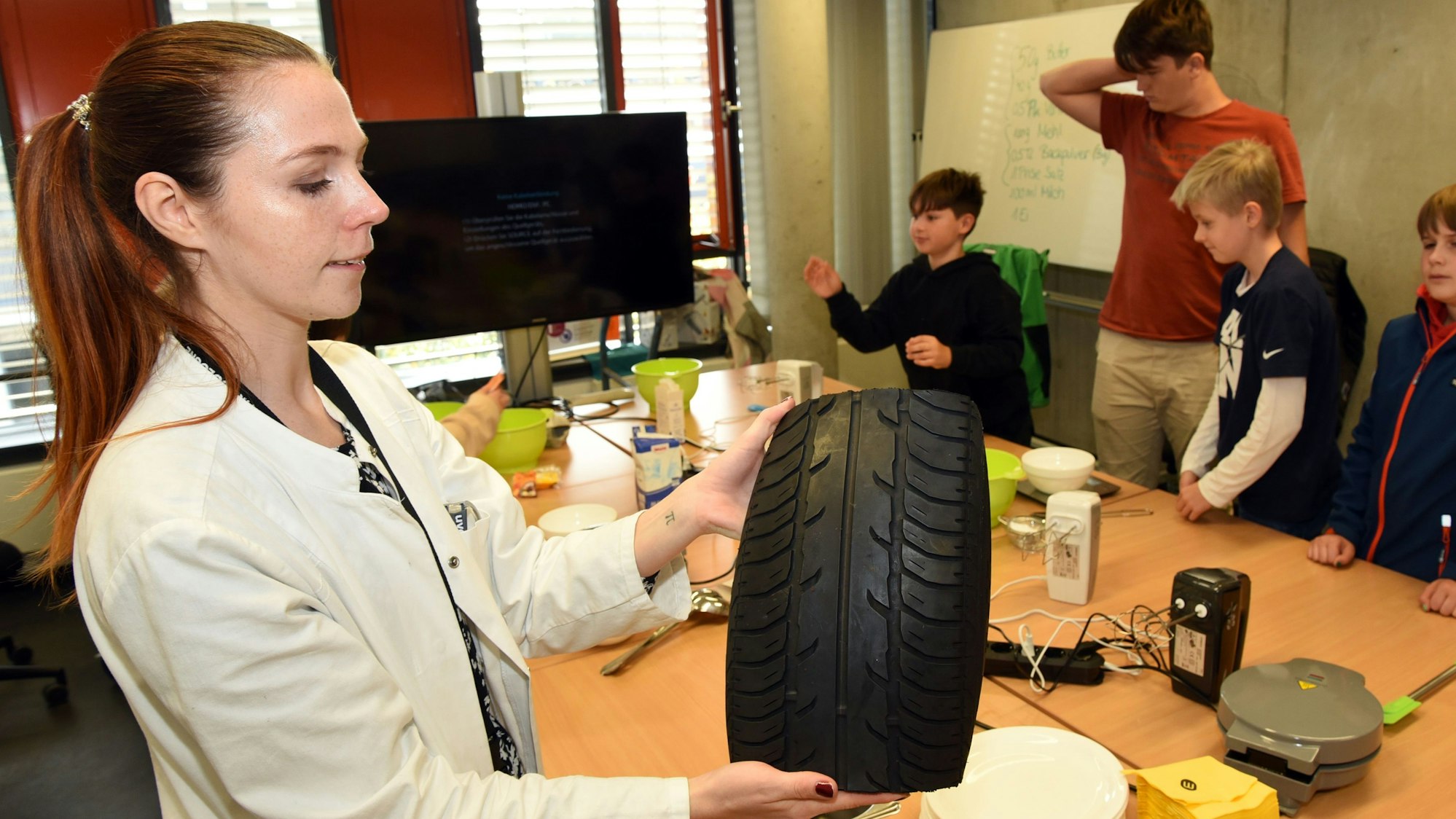 Die wissenschaftliche Mitarbeiterin Vanessa Spanheimer zeigt ein Stück Autoreifen.