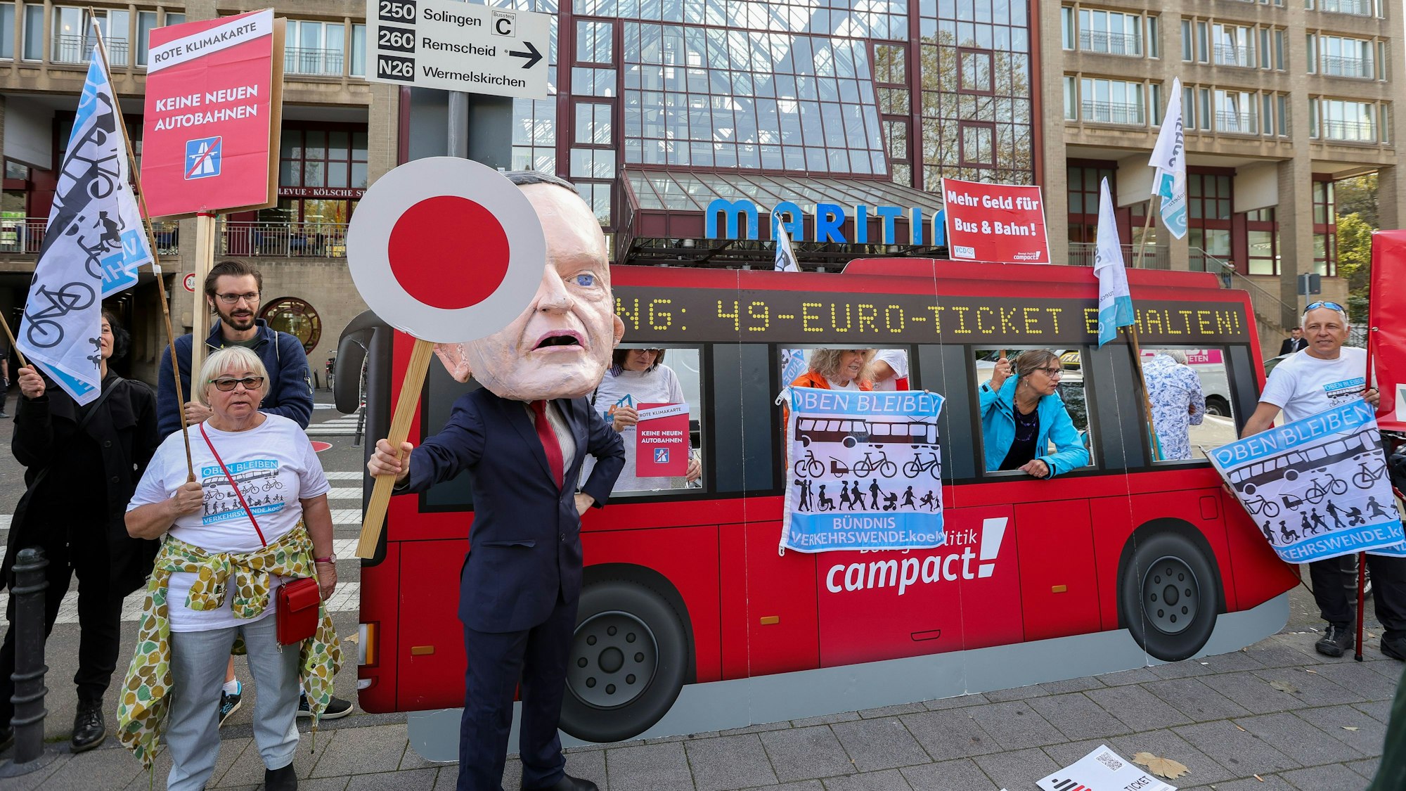 Ein großes Plakat und weitere Menschen vor dem Maritim Hotel.