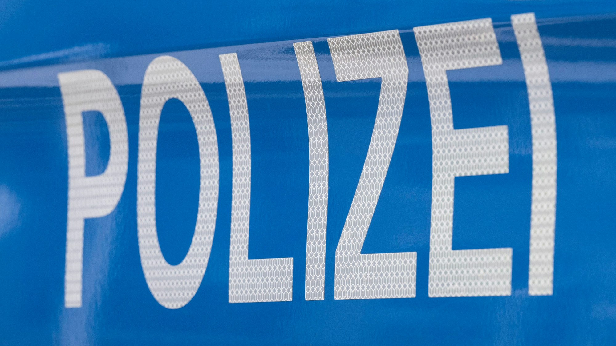 Polizei-Schriftzug auf einem Polizeiwagen. (Symbolbild)