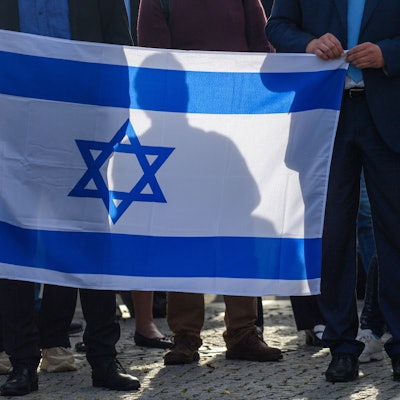 Teilnehmer einer Solidaritätskundgebung für Israel halten die Fahne Israels in den Händen. Terroristen hatten am Samstag im Auftrag der im Gazastreifen herrschenden Hamas ein Massaker unter israelischen Zivilisten in Grenzorten und auf einem Musikfestival angerichtet. +++ dpa-Bildfunk +++