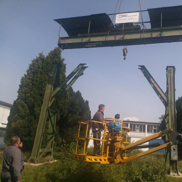 Arbeiter arbeiten von einem Hubsteiger aus am Wiederaufbau des alten Portalkrans vom Gelände des Morsbacher Bahnhofs. Der hat in Wissen an der Sieg einen neuen Platz gefunden.