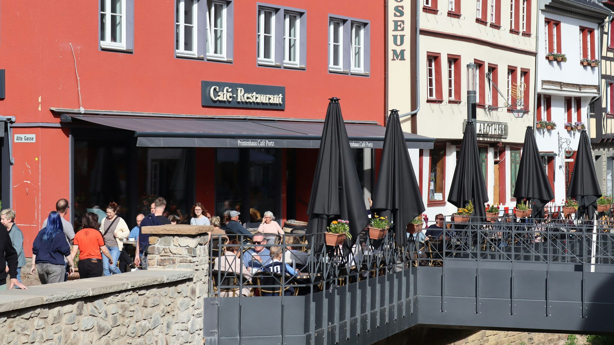 In der Bad Münstereifeler Innenstadt sitzen zahlreiche Gäste draußen an den Tischen der Gastronomiebetriebe.