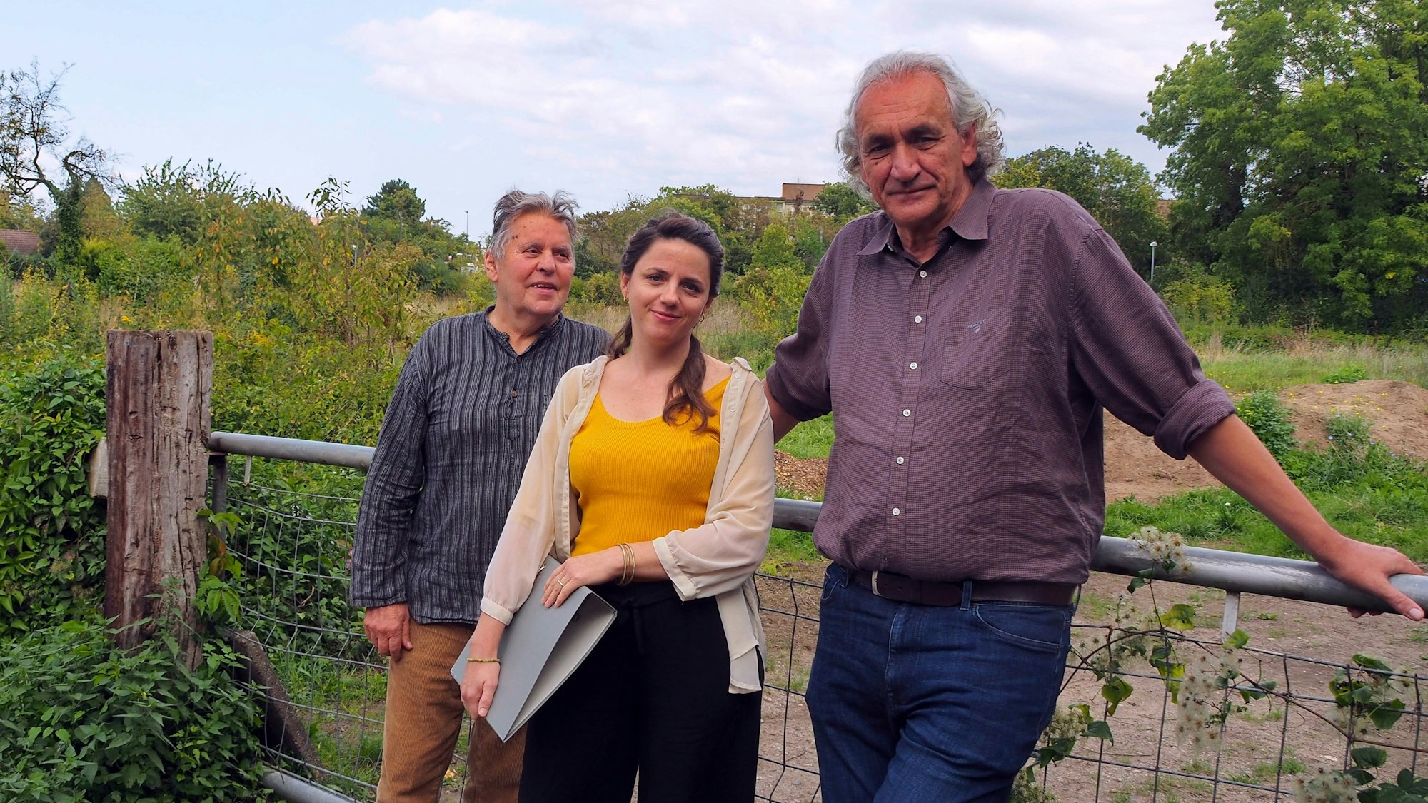 Die drei Verantwortlichen stehen vor dem Grundstück.