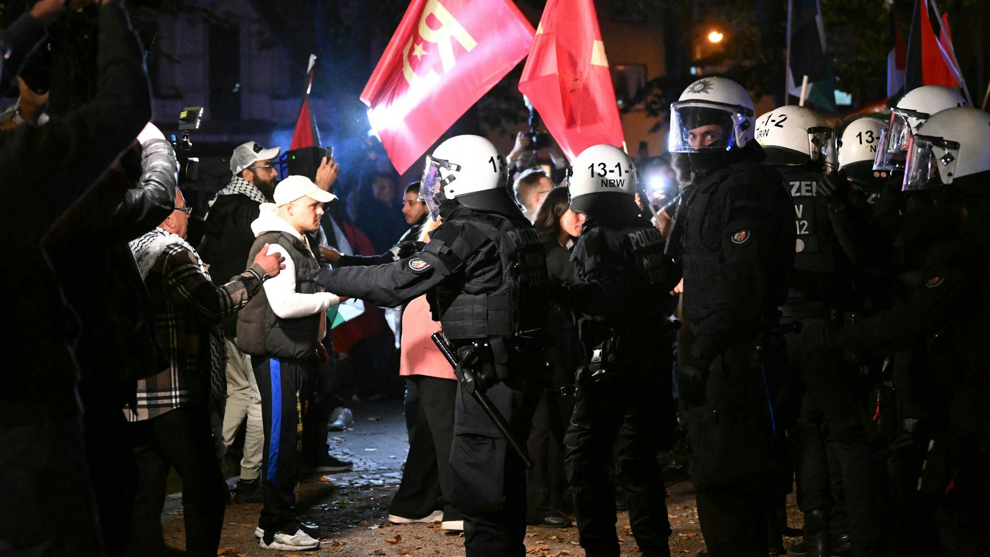 Polizisten halten Teilnehmer einer israelfeindlichen Demonstration in Duisburg am Montag zurück.