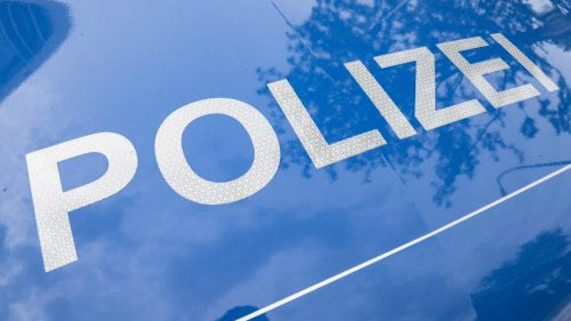 Die Polizei, hier ein Symbolbild mit einem Polizei-Schriftzug, sucht zwei Unbekannte, die eine Spielhalle in Sindorf überfallen haben.