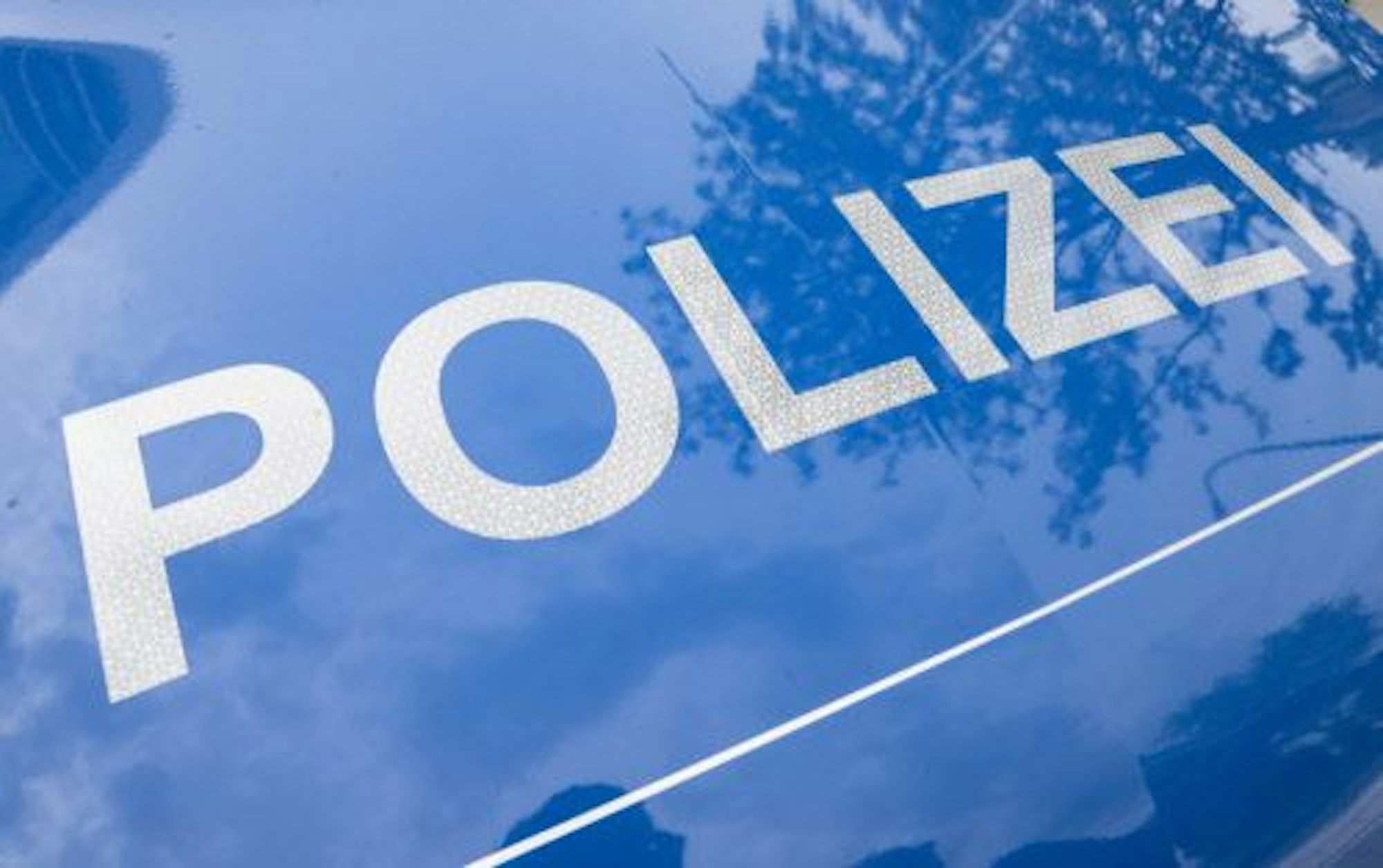 Polizei-Schriftzug auf einer Motorhaube.