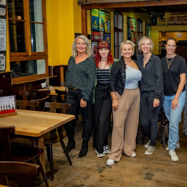 Mica Frangenberg (v.l.), Jo Eicker, Nici Kempermann, Sophie Gesthuysen, Anna Heller, Nadine Krahforst und Vera Drewke (nicht auf dem Bild) stehen in einer Kneipe.