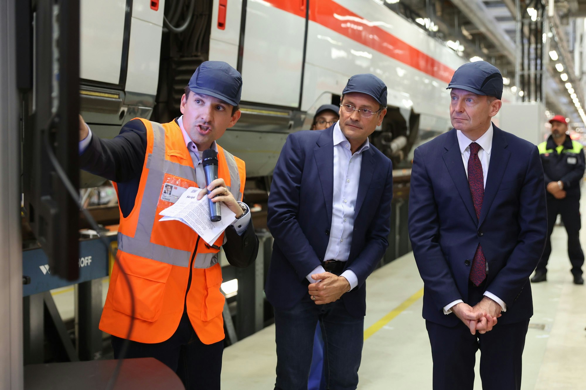 Drei Männer stehen an einem ICE