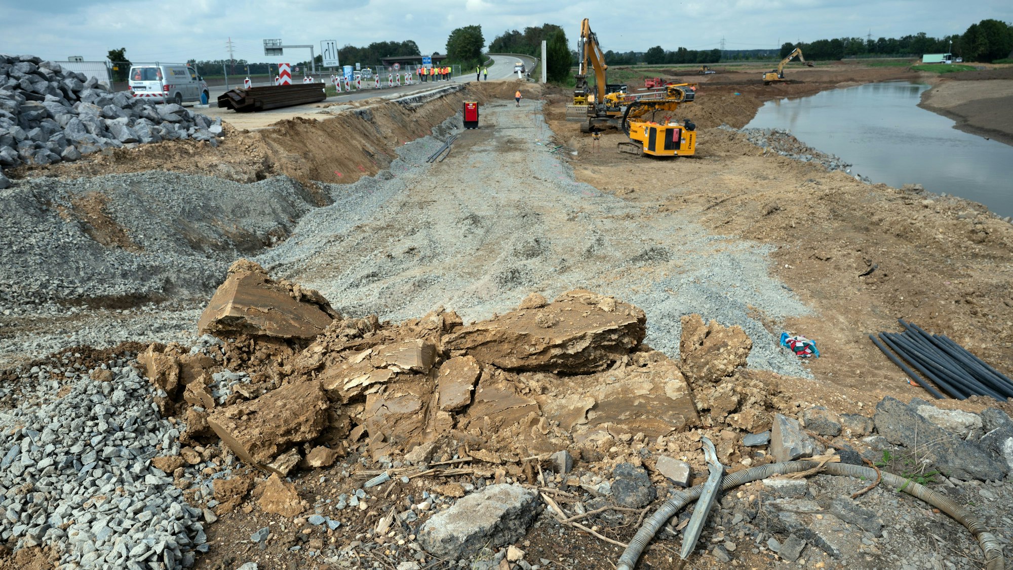 Baumaschinen arbeiten an der Autobahn 1 bei Erftstadt, um die weggespülte Fahrbahn wieder aufzubauen.