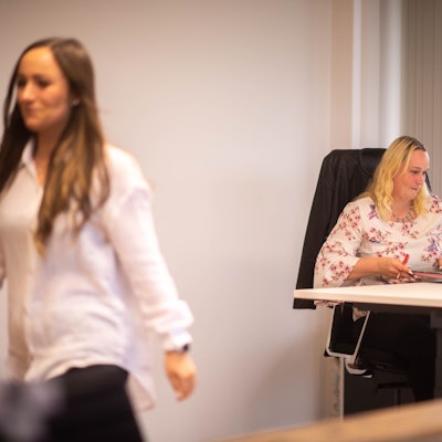 Das Bild zeigt Simone Limbach am Schreibtisch im Kreishaus. Luisa Vogelsberg verlässt gerade das Büro.