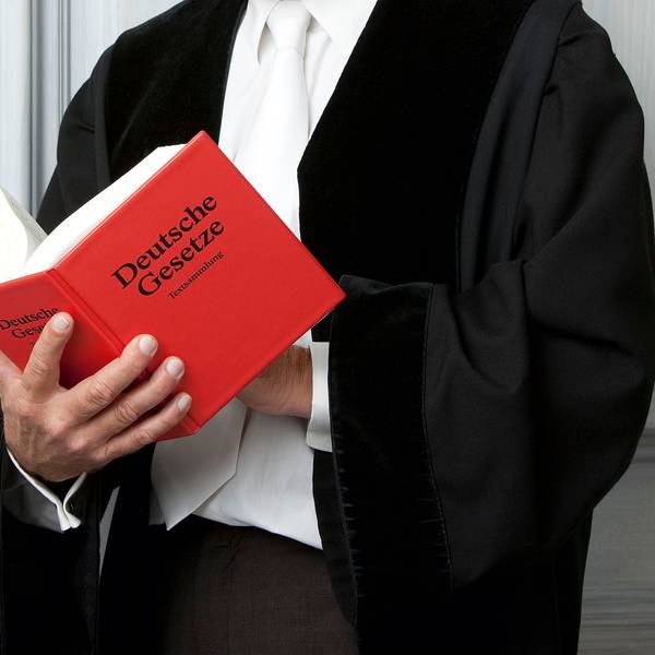 Ein Anwalt liest ein Gesetzebuch.