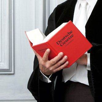 Ein Anwalt liest ein Gesetzebuch.