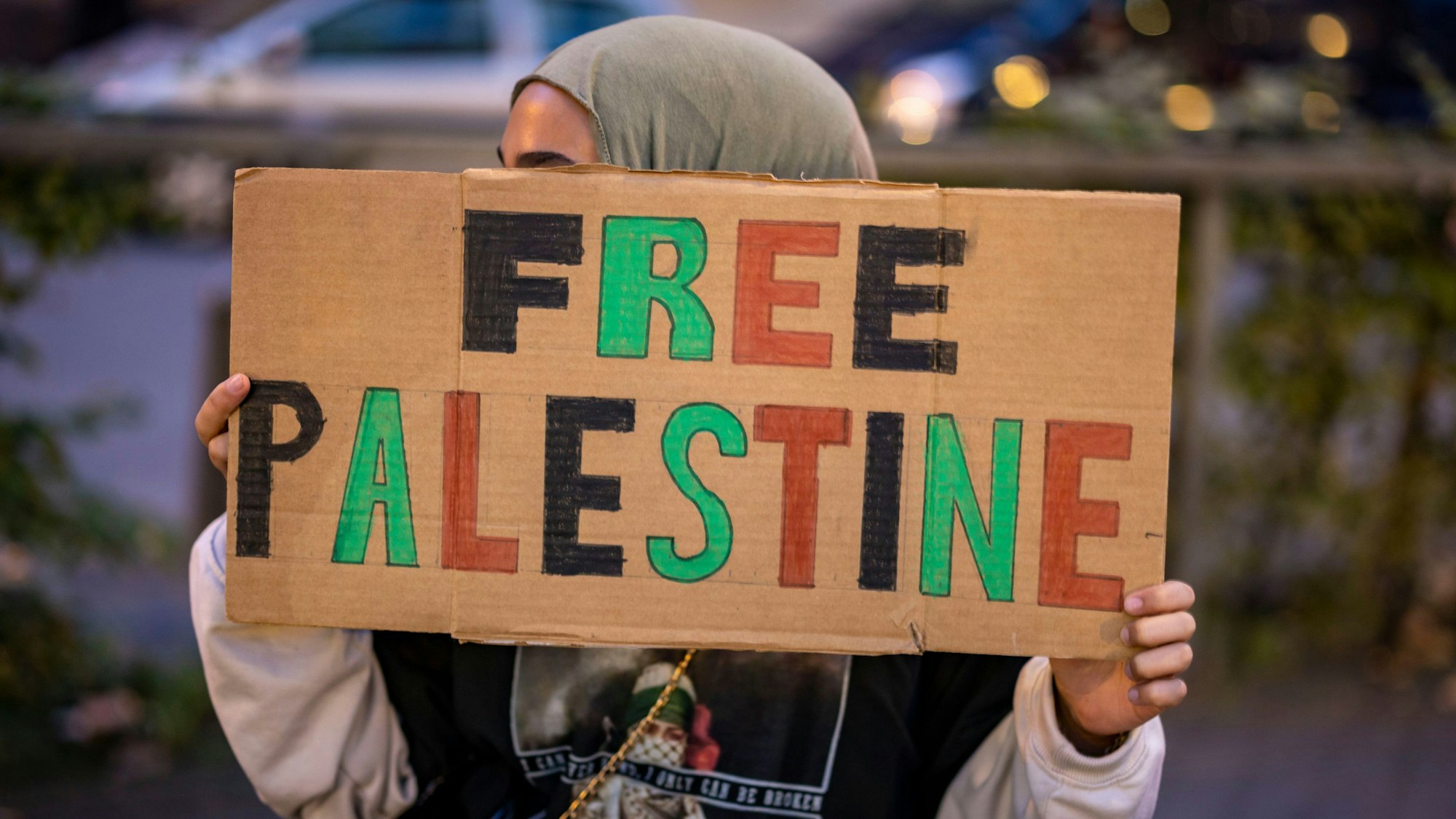 Eine Frau hält in Duisburg ein Schild mit der Aufschrift «Free Palestine» während einer pro-palästinensischen Kundgebung hoch.